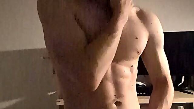 Youthful man wanking standing in front of the camera
